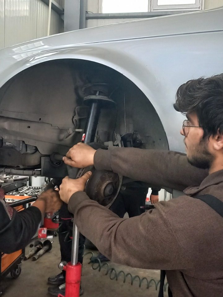 Elev de la Liceul Tehnologic Constantin Istrati reparând un vehicul într-un service auto partener